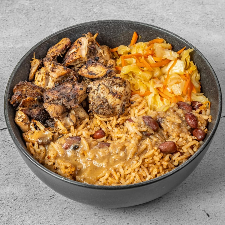 A bowl of The Jungle Plate's African-fusion jerk chicken, rice and peas, and steamed cabbage.